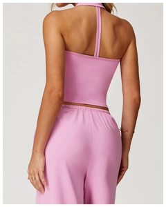Detail view of pink halter sports bra with criss-cross back design and matching leggings
