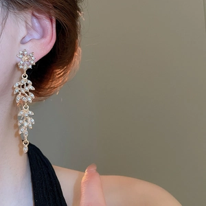 Vue macro détaillée d'élégantes boucles d'oreilles épi de blé dorées avec cristaux brillants
