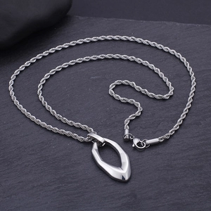 Macro detail of silver-tone irregular waterdrop pendant on twisted rope chain