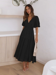 Close-up of elegant V-neck puff sleeve dress with waist tie and layered hemline