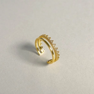 Close-up of golden double-layer open ring with crown texture and sparkling white zircons