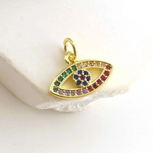 Macro shot of evil eye pendant featuring colorful cubic zirconia on polished gold frame