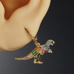 Golden dinosaur earrings with colorful zircon crystals on a female ear model