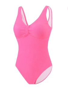 Détail du tissu texturé rose pêche sur un maillot de bain une pièce sexy à col en V