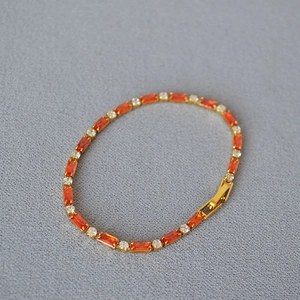 Detailed macro view of gold plated brass bracelet with orange and white zircon stones
