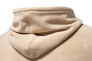Macro shot of beige polar fleece hoodie featuring reinforced stitching and soft texture