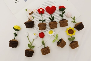 Detailed overhead view of assorted handmade crochet mini potted plants with wool flowers