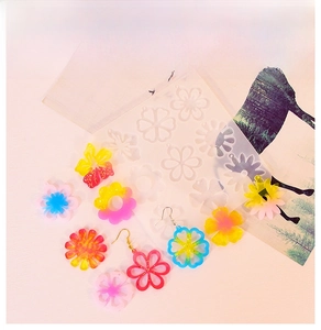 Detail view of flower-shaped silicone molds for resin earrings with colorful DIY samples