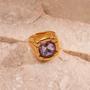 Detailed macro view of a vintage gold steel ring featuring a square purple zircon stone
