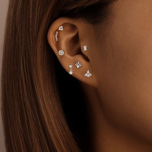 Detailed close-up of 925 sterling silver drop zircon earring on model ear cartilage