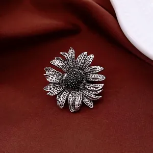 Vintage sunflower brooch with antique silver finish and black bead center on fabric
