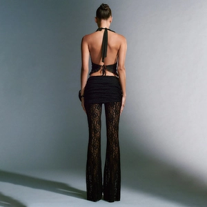 Detailansicht der schwarzen Spitzenhose mit ausgestelltem Bein und Neckholder-Top