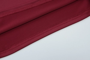 Detail of wine red knit top featuring high-quality double-needle hem and fine stitching