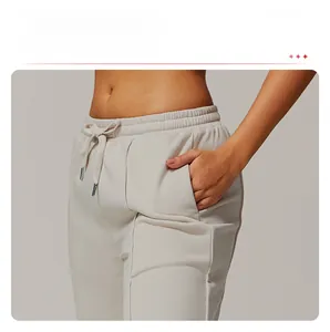 Detail of high-waist drawstring joggers featuring functional side pockets and premium fabric