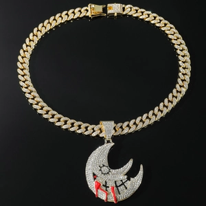 Close-up of iced out gold moon pendant with red blood drip on Cuban link chain