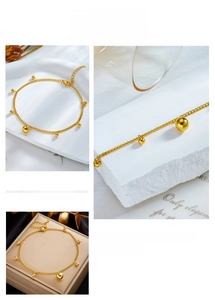 Detail of gold-plated stainless steel anklet with lobster clasp and bead pendants