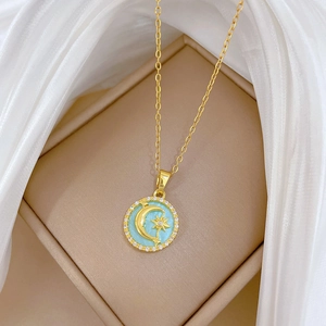 Detail of gold moon and star pendant with blue enamel and sparkling crystals