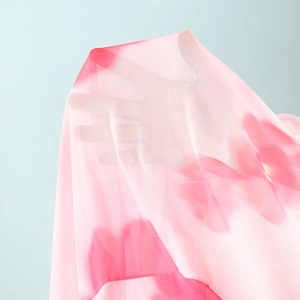 Close-up of lightweight pink gradient mesh fabric showing sheer texture and fine netting