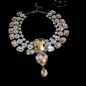 Detailed macro view of crystal necklace featuring heart, square, and teardrop-shaped pendants
