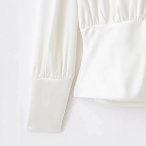 Élégante chemise blanche en satin à manches longues avec taille froncée et poignets