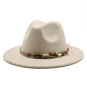 Détail d'un chapeau fedora en laine beige avec ruban décoratif à perles colorées ethniques