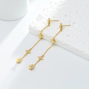 Detail shot of golden star tassel earrings showing the S925 silver hallmark on the back