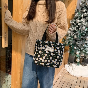 Petit sac fourre-tout en toile noire avec broderie marguerite blanche et anses tissées