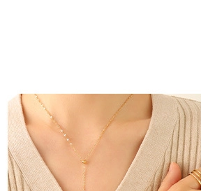 Detail of a gold-plated oval textured pendant necklace with a minimalist Y-shape design