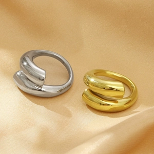 Minimalist gold and silver open wrap rings on champagne silk background