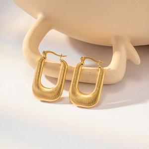 Détail de boucles d'oreilles en U plaquées or 18 carats avec texture striée et fermoir sécurisé