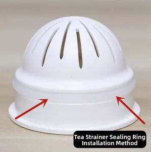 Detail view of white plastic tea strainer with red arrow indicating seal ring installation