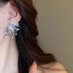 Detailed view of silver starburst earrings with pearls worn by model for elegant style