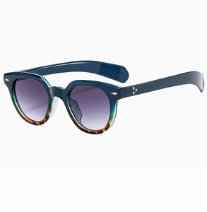 Detail view of oval retro sunglasses with blue frames, tortoiseshell tips, and gradient lenses