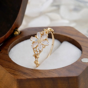 Macro shot of vintage floral ring with opal stone and gold band in a wooden jewelry box