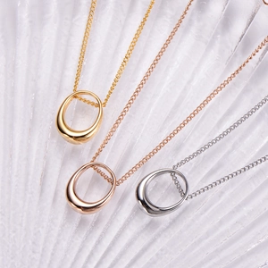 Close-up of minimalist teardrop necklaces in gold, rose gold, and silver finishes
