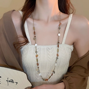 Vista dettagliata di una collana vintage con nappe e pietre indossata da una modella