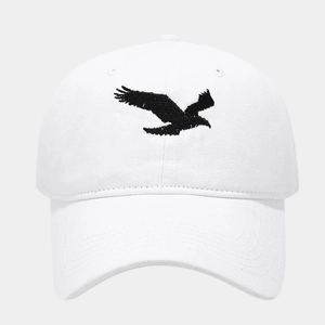 Close-up of black eagle embroidery on a white washed cotton baseball cap, soft crown