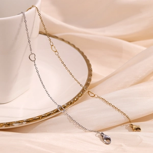 Close-up of gold and silver heart link bracelets on elegant champagne silk fabric