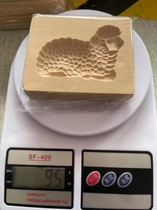 Macro shot of rectangular beech wood cookie mold featuring a detailed carved sheep pattern