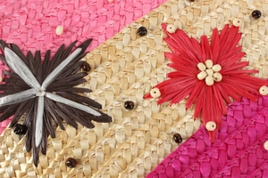 Détail de la texture en paille tressée rose avec fleurs brodées et détails de perles