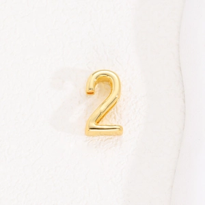Macro detail of gold number 2 charm for 10mm stainless steel mesh bracelet