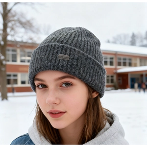 Close-up of grey knit beanie featuring a metallic logo tag and premium ribbed texture