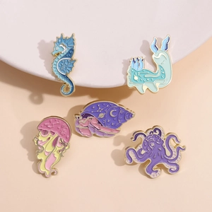 Five-piece set of ocean creature enamel pins with gold star and moon celestial motifs