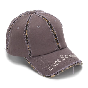 Détail du patchwork léopard et de la broderie sur une casquette de baseball délavée