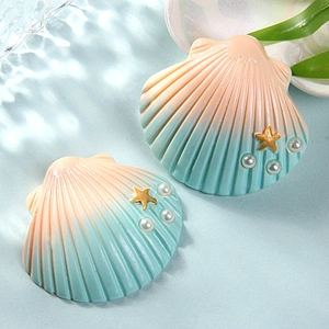 Detailed view of pink and blue resin shells with golden starfish and small pearl accents