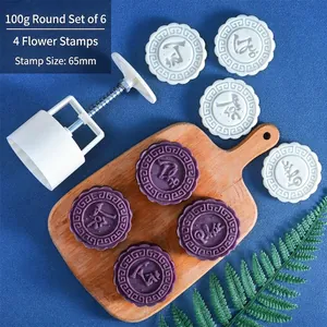 Macro detail of a 100g round mooncake mold set with 4 stamps and a handheld press tool
