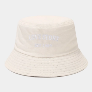 Detail of LOVE STORY embroidery and reinforced stitching on cream cotton bucket hat
