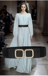 Detail of black elastic waist belt with pearl-embellished double square buckle on a dress