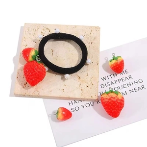Black elastic hair tie featuring realistic resin strawberry charms and small pearls