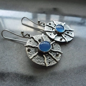 Vintage silver sunburst earrings with blue stone inlay and hammered metal texture